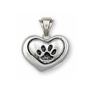 May include: A silver heart-shaped pendant with a paw print design. The pendant is a memorial piece for a pet.