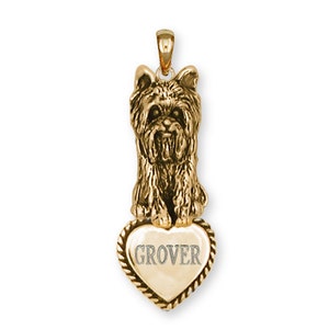 May include: Gold-tone pendant featuring a Yorkshire Terrier dog sitting on a heart-shaped charm with the name "GROVER" engraved on it.
