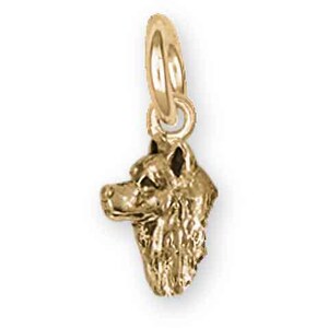May include: A gold-colored pendant charm in the shape of a dog's head. The charm is detailed with fur and facial features, and has a loop at the top for attaching to a necklace or bracelet. The charm is likely made of gold.