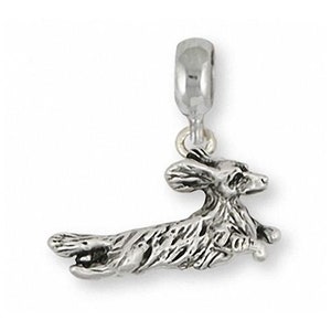 May include: Silver charm of a dachshund dog running, designed for a charm bracelet.