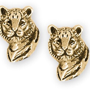 May include: A pair of gold-toned tiger head stud earrings. The earrings are detailed with a realistic depiction of a tiger's face.