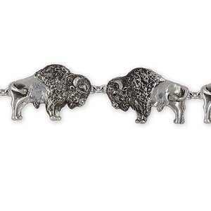 Puede incluir: Una pulsera de plata con una cadena y varios abalorios de búfalo. Los abalorios de búfalo son detallados y tienen un acabado texturizado.
