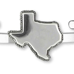 Puede incluir: Una pulsera de puño plateada con un contorno detallado del estado de Texas. El dije en forma de Texas tiene un borde texturizado y está centrado en la banda lisa de extremo abierto. Una joya sencilla y elegante.