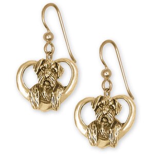 May include: Gold-tone heart-shaped earrings featuring a detailed miniature Schnauzer dog charm.