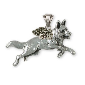 May include: A silver German Shepherd dog pendant with gold wings. The dog is depicted in mid-air, as if it is flying. The pendant is a memorial piece for a beloved pet.