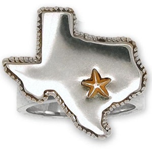 Puede incluir: Un anillo de plata con forma del estado de Texas con una estrella dorada en el centro.