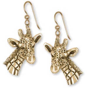 May include: A pair of gold-colored giraffe head earrings. The earrings feature detailed giraffe head pendants with textured surfaces, including the characteristic spots. The earrings have a hook closure.