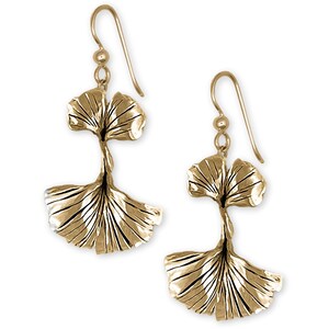May include: Gold-tone earrings featuring a double ginkgo leaf design. The leaves are textured and have a realistic look.
