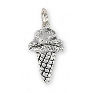May include: A silver charm in the shape of an ice cream cone with a scoop of ice cream on top.