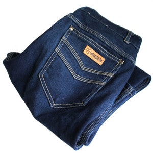 May include: A pair of dark blue denim jeans folded in half, with a brown leather patch that says "GIANO" on the back pocket.
