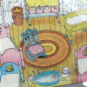 Puede incluir: Una ilustraci&oacute;n colorida de una habitaci&oacute;n de beb&eacute; con una mecedora, una cuna, una mesa para cambiar pa&ntilde;ales, una ba&ntilde;era para beb&eacute; y una cesta de mimbre. La habitaci&oacute;n tiene una combinaci&oacute;n de colores rosa y azul y presenta una alfombra redonda con c&iacute;rculos conc&eacute;ntricos.