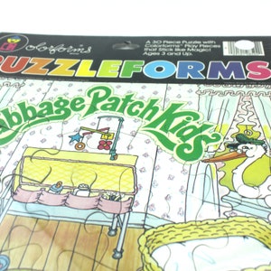 Puede incluir: Un rompecabezas Colorforms de 30 piezas que representa una escena de guarder&iacute;a de Cabbage Patch Kids. El rompecabezas incluye una cuna, una mesa para cambiar pa&ntilde;ales, un m&oacute;vil y una cig&uuml;e&ntilde;a que entrega un beb&eacute;. Las piezas del rompecabezas est&aacute;n hechas de pl&aacute;stico colorido y duradero y est&aacute;n dise&ntilde;adas para pegarse como por arte de magia.