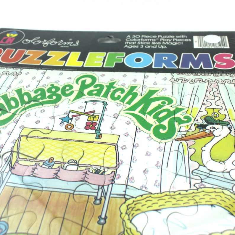 Puede incluir: Un rompecabezas Colorforms de 30 piezas que representa una escena de guarder&iacute;a de Cabbage Patch Kids. El rompecabezas incluye una cuna, una mesa para cambiar pa&ntilde;ales, un m&oacute;vil y una cig&uuml;e&ntilde;a que entrega un beb&eacute;. Las piezas del rompecabezas est&aacute;n hechas de pl&aacute;stico colorido y duradero y est&aacute;n dise&ntilde;adas para pegarse como por arte de magia.