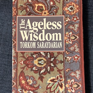 May include: A book titled "The Ageless Wisdom" by Torkom Saraydarain. The cover features a colorful floral pattern.
