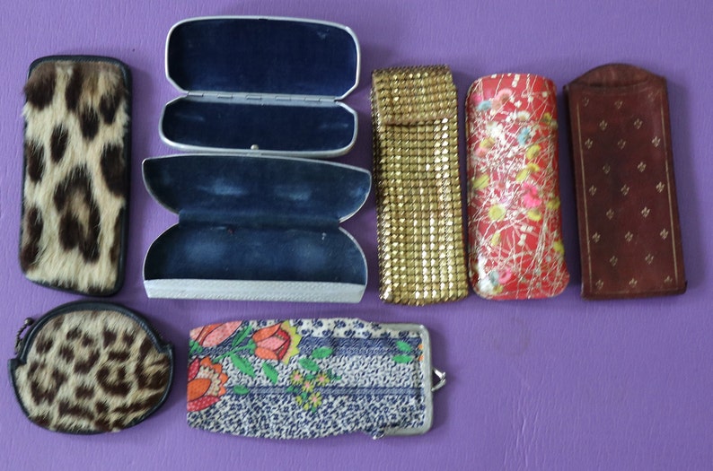 May include: Assortment of vintage eyeglass cases in various materials and patterns, including leopard print, floral, and metallic mesh.