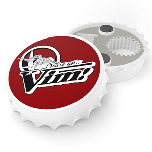 以下が含まれることがあります： 「You've got... Vim!」の文字とグラフィックが描かれた赤い円形デザインの白いボトルオープナー。ボトルオープナーは金属製で、白く縁が波打っています。デザインは白黒です。
