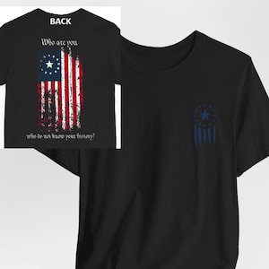 May include: Black t-shirt with a distressed American flag design on the back. The flag has 13 stars in a circle. The front of the shirt has a smaller version of the flag in blue on the left chest. The text on the back says "Who are you? Who do not know your history?"