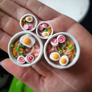 Ramen Plugs Polymer clay in a stainless steel tunnel, miniature food polymer clay plugs.