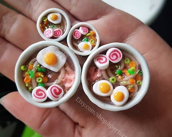 Ramen Plugs Polymer clay in a stainless steel tunnel, miniature food polymer clay plugs.