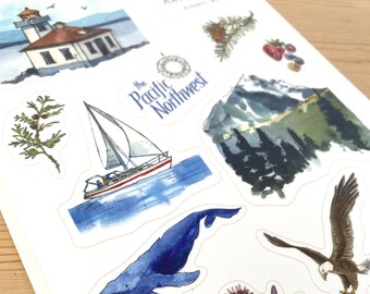 May include: A set of stickers featuring watercolour illustrations of the Pacific Northwest. The stickers include a lighthouse, a sailboat, a whale, a crab, a starfish, a sea urchin, a mountain range, a pine tree, and a bald eagle. The stickers are printed on white paper and have a glossy finish.