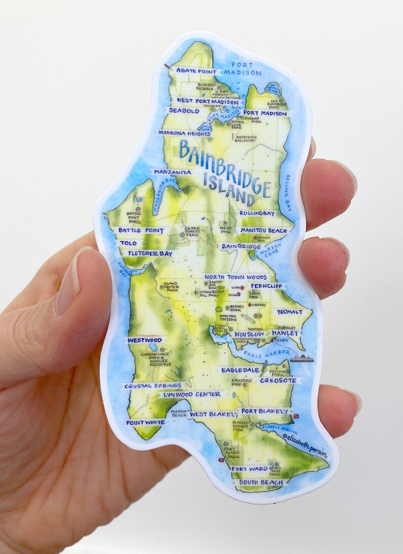 K&ouml;nnte beinhalten: Eine Aquarellkarte von Bainbridge Island, Washington, mit blauem Wasser und gr&uuml;nem Land. Die Karte zeigt die Lage verschiedener Sehensw&uuml;rdigkeiten, darunter Parks, Str&auml;nde und Stadtteile. Die Karte ist von einem wei&szlig;en Rand umgeben.