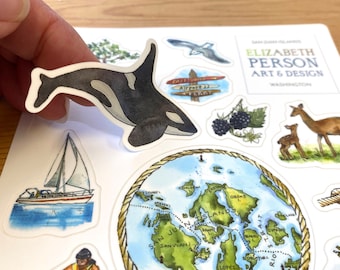 May include: A set of colourful stickers featuring illustrations of a sailboat, a map of the San Juan Islands, a black and white orca whale, a deer and fawn, and a blackberry bush. The stickers are on a white background and have a hand-painted watercolour style. The text "SAN JUAN ISLANDS" and "ELIZABETH PERSON ART & DESIGN" is visible on the stickers.
