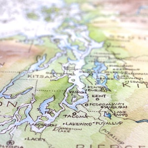 May include: A watercolor map of the Puget Sound region of Washington state, showing the cities of Tacoma, Kent, Federal Way, Auburn, Puyallup, Lakewood, Vashon, and Kitsap. The map is painted in shades of green, blue, and brown.