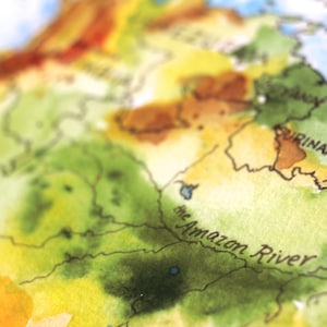 May include: A watercolor painting of a map of South America, with the Amazon River labeled in black text. The map is painted in shades of green, yellow, and brown.