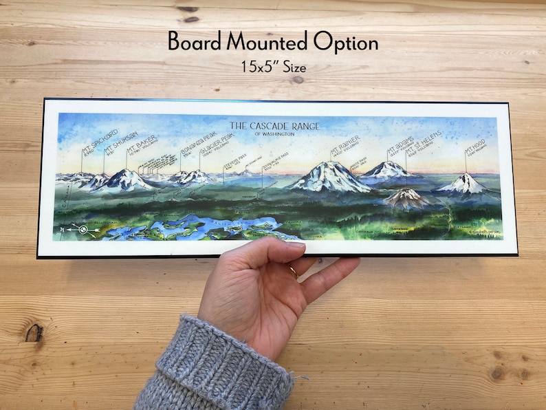 K&ouml;nnte beinhalten: Eine Aquarell-Illustration der Cascade Range im Bundesstaat Washington, mit den Namen der Berge, darunter Mount Rainier, Mount St. Helens und Mount Hood. Die Illustration ist auf einem 15x5 Zoll gro&szlig;en Brett montiert.