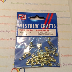 May include: A clear plastic bag filled with 32 gold safety pins. The bag is labeled "Westrrim Crafts" and "3/4" Safety Pin, Epinglé de Sureté 1.9CM".