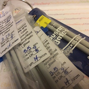 May include: Close-up of three packages of knitting needles. The packages are labeled with the size and material of the needles. The needles are silver in color and are packaged in clear plastic. The packages are labeled with the brand name "Susan Bates" and "Quicksilver".