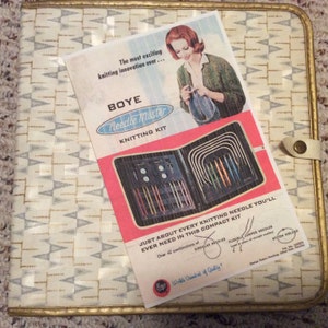 Peut inclure: Une trousse à tricoter vintage Boye Needle Master aux couleurs rouge, blanc et bleu. La trousse comprend une variété d'aiguilles et un étui pour les ranger. Le texte sur le devant de l'étui indique "Boye Needle Master Knitting Kit".