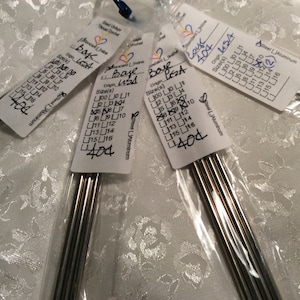 May include: Four packages of steel crochet hooks. Each package has a label with the text "Base USA" and size options. The labels also include the number "404". The hooks are silver and appear to be new.