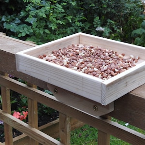 Little wooden rectangular bird table to fit on fence top for wild or garden birds.