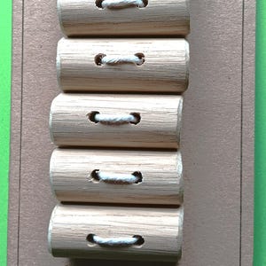 May include: Six oak toggle buttons with white cord loops, arranged vertically on a brown card. The card has rounded corners and text that reads "Oak toggle buttons by justdriftingthrough."