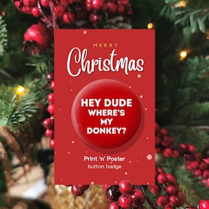 May include: A red button badge with the text "MERRY Christmas" at the top. The badge has a red circle with the words "HEY DUDE WHERE'S MY DONKEY?" and the text "Print 'n' Poster button badge". The background is a Christmas tree.