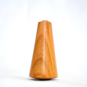 May include: A wooden spinning top with a conical shape and a smooth, light brown finish.