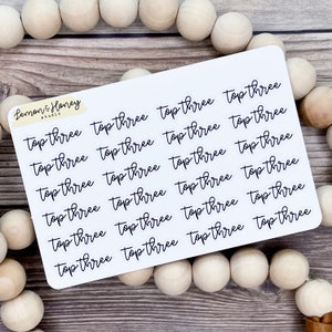 May include: A sheet of white sticker paper with 18 black and white stickers that say "top three" in a handwritten font.