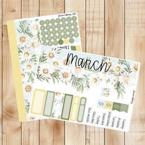 May include: A printable planner sticker sheet with a floral design featuring white daisies and green leaves. The sheet includes a calendar, a monthly planner, and a weekly planner. The text "March" is featured on the monthly planner.