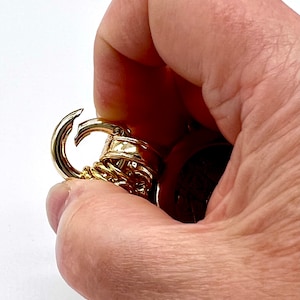 May include: Gold-toned chain with a lobster clasp. The chain is made of multiple linked rings.