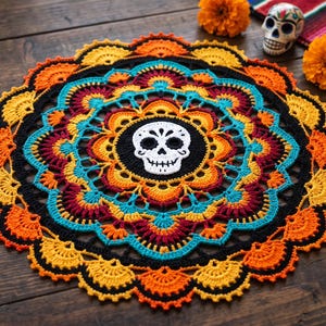 Peut inclure: Un napperon au crochet circulaire présentant un motif de crâne blanc central sur fond noir, entouré de couches concentriques de fils orange vif, turquoise, rouge foncé et jaune dans un motif mandala détaillé, festonné et complexe.
