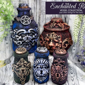 May include: Five decorative bottles with ornate metalwork and stoppers. The bottles are blue, green, and purple with gold and silver accents. The bottles are labeled "The Enchanted Relics Vessel Collection (see other listings for the rest)".