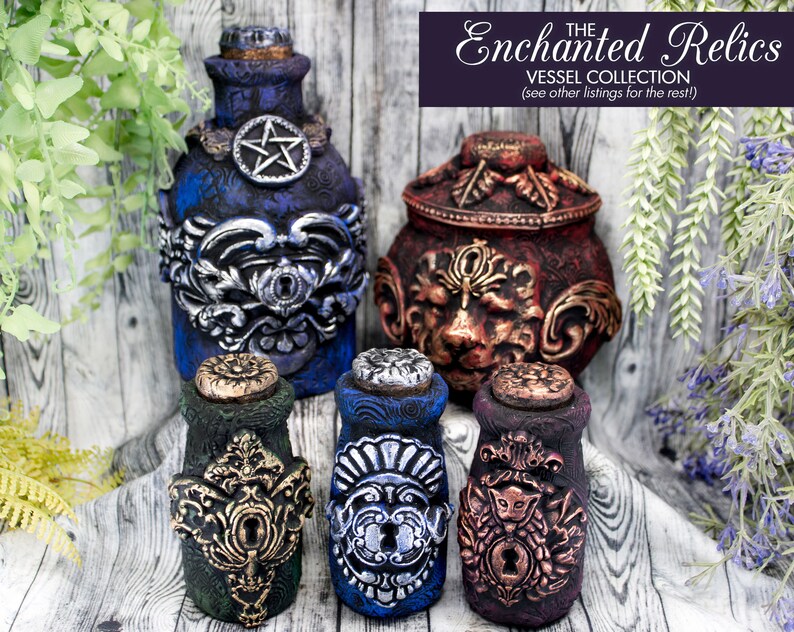 May include: Five decorative bottles with ornate metalwork and stoppers. The bottles are blue, green, and purple with gold and silver accents. The bottles are labeled "The Enchanted Relics Vessel Collection (see other listings for the rest)".