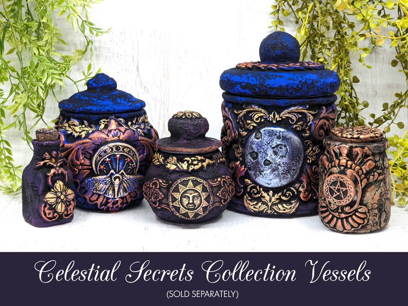 May include: A collection of four decorative ceramic jars with intricate designs. The jars are painted in shades of blue, purple, gold, and copper. Each jar features a different celestial motif, including a moon, sun, and stars. The jars are labeled "Celestial Secrets Collection Vessels (SOLD SEPARATELY)".