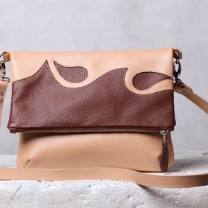 Sac à bandoulière en cuir. Sac à bandoulière. Sac à main en cuir beige et en cuir brun. Sac à main en cuir applique pour le corps.