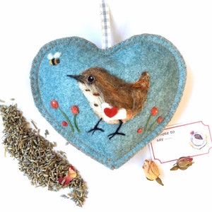 Enviando amor con aguja de fieltro, reyezuelo con carta y flores de fieltro