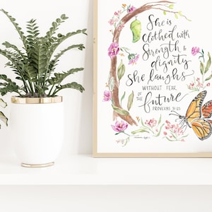 Könnte beinhalten: Aquarelldruck mit einem Schmetterling, Blumen und einem Zitat, das lautet: "Sie ist bekleidet mit Stärke und Würde. Sie lacht ohne Angst vor der Zukunft. Sprichwörter 31:25."