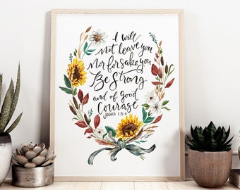 May include: A framed print with a watercolor illustration of a sunflower wreath. The wreath has sunflowers, leaves, and flowers in shades of red, yellow, green, and white. The text in the center reads "I will not leave you nor forsake you. Be strong and of good courage. Joshua 1:5-9."