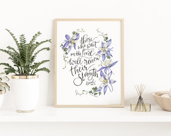 May include: A framed print featuring a watercolour illustration of purple and white flowers. The text reads "Those who wait on the Lord will renew their strength. Isaiah 40:31."