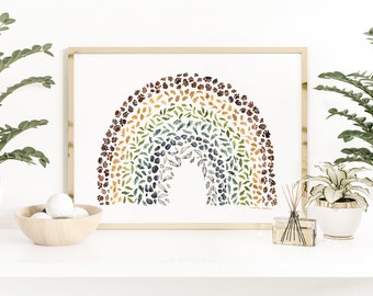 May include: A framed watercolor print of a rainbow made of leaves, pine cones, and other natural elements. The rainbow is a light brown, yellow, green, blue, and dark brown color.